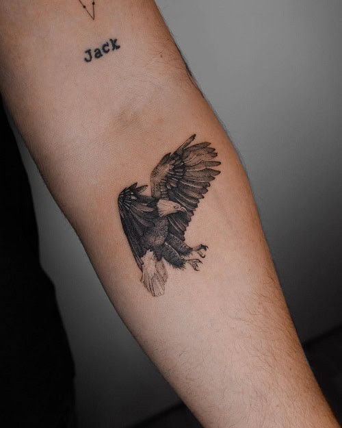 Small arm tattoo with a simple symbol on a man's upper arm