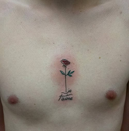 Small chest tattoo with lettering over a man's chest