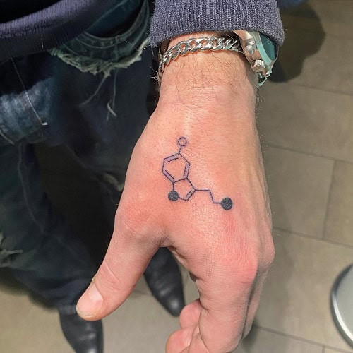 Small hand tattoo with a geometric design on a man's hand