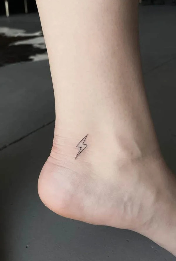 Small lightning foot tattoo, symbolizing speed, accuracy, strength, and determination, a simple yet badass design