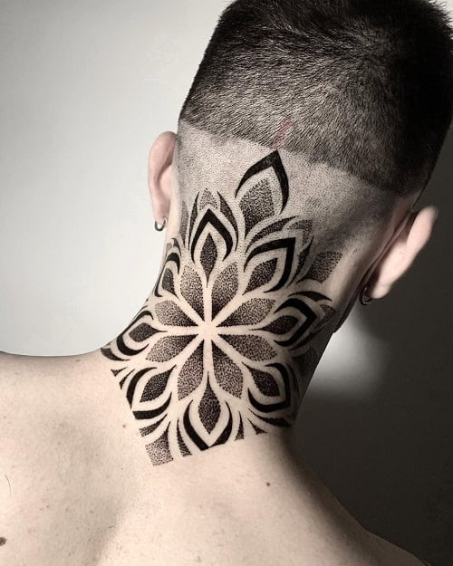 Small mandala tattoo with intricate geometric patterns on a man's forearm