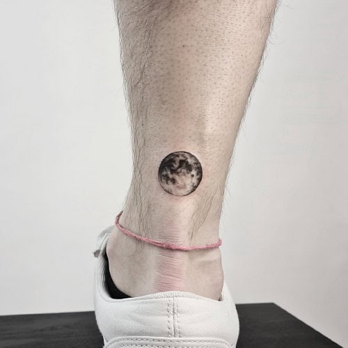 Small crescent moon tattoo with shading on a man's neck