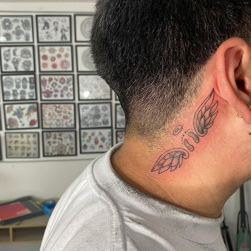 Small neck tattoo with a delicate design on a man's neck