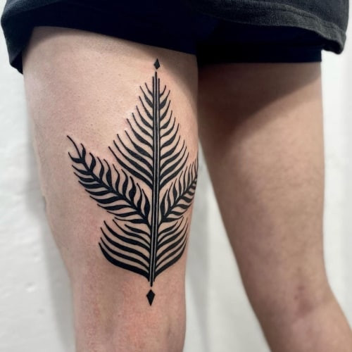 Simple and delicate floral sprig tattoo on a man's hand