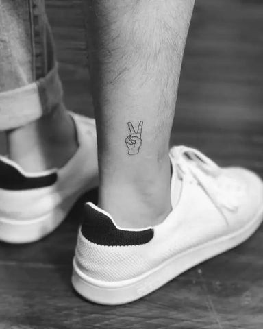 Discreet small leg tattoo for men with a subtle and meaningful symbol