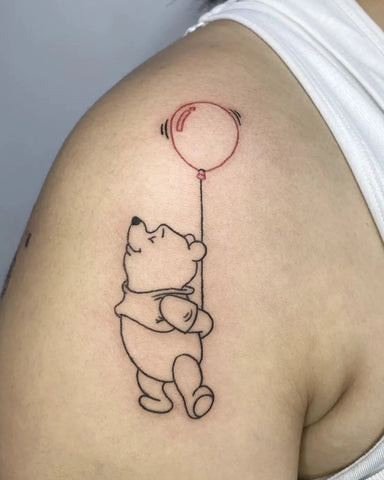 A small compass tattoo on a man's shoulder near the collarbone