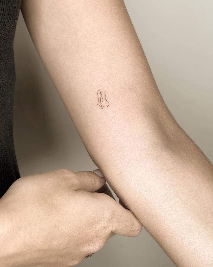 A simple tattoo of intertwined circles on a woman's wrist, representing unity and interconnectedness.