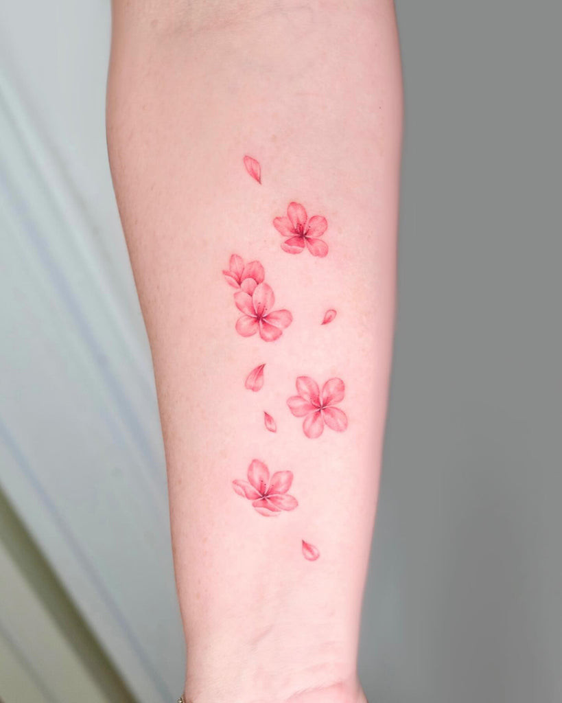 A small, playful tattoo of cartoon-style cherries on a woman's ankle, adding a touch of whimsy and fun.