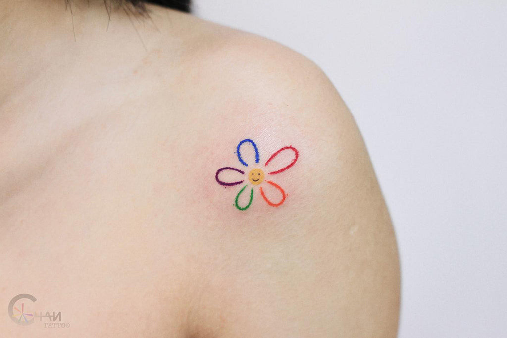 A minimalist single-line drawing of a flower on a woman's arm, showcasing elegant simplicity in botanical tattoos.