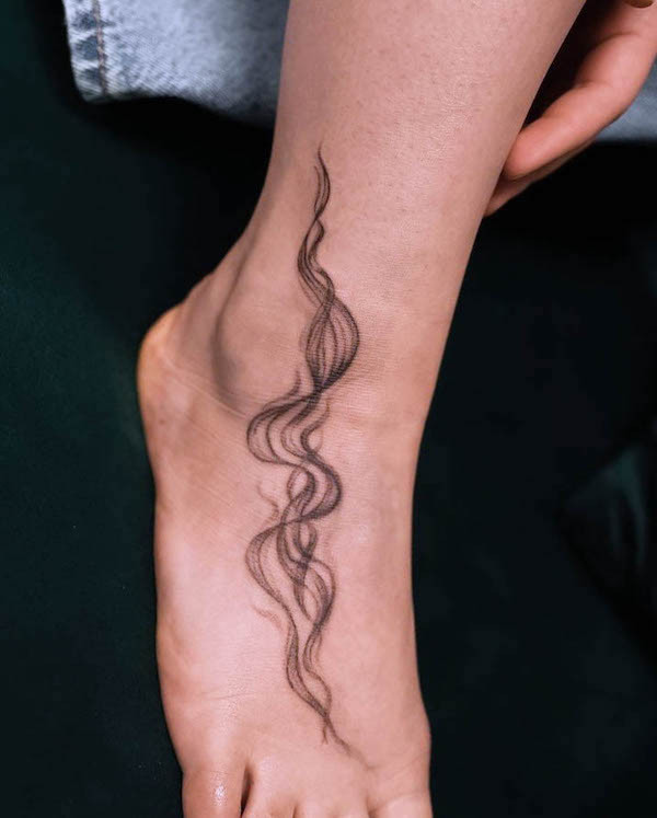 Smoke foot tattoo, a whimsical design capturing the flowing motion of smoke, creating movement on the skin