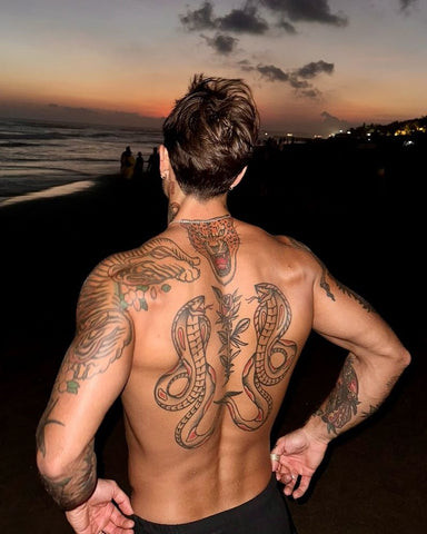 A snake back tattoo winding along the spine, symbolizing transformation and rebirth.