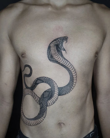 Man with a snake chest tattoo featuring a snake winding across his chest