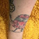 A whimsical brain tattoo with arms, legs, a lightning bolt, and a bandage, representing Stacy's "tumorversary" celebration.