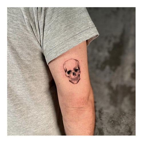 Simple stick and poke smiley face tattoo on a man's ankle