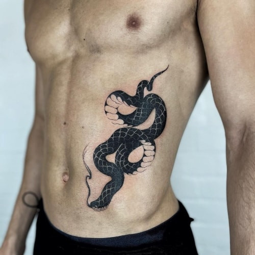 Stomach tattoo with a floral design, a flowing and organic placement for men.