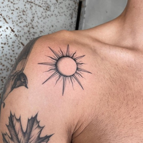 Realistic sun and moon tattoo on a man's arm