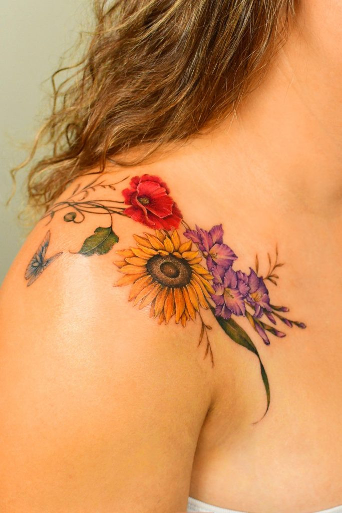 Bright sunflower shoulder tattoo cover-up by Yerae, showing her skill in using bold colors for floral tattoo transformations.