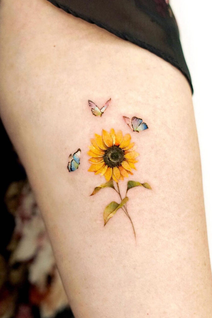 Small realistic sunflower arm tattoo with colorful butterflies