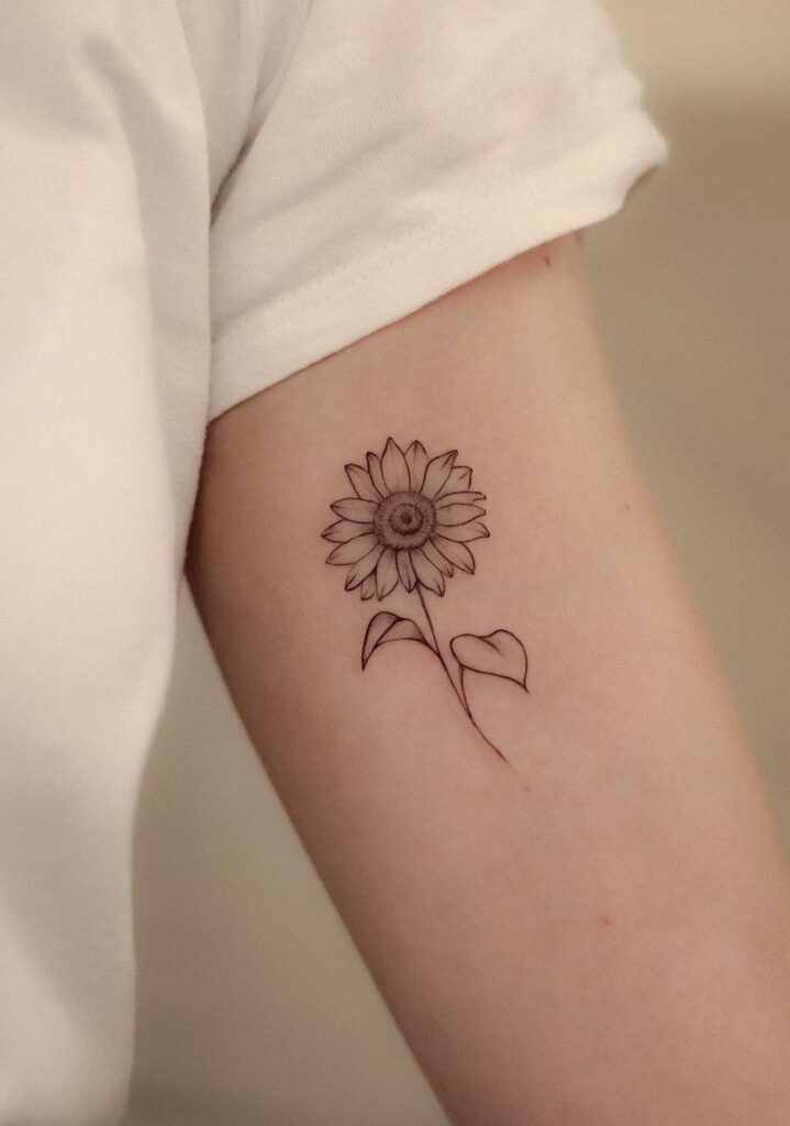 Delicate line art sunflower arm tattoo