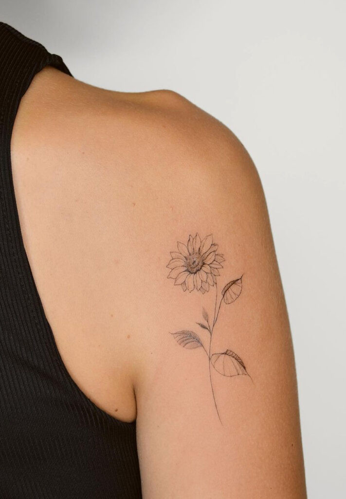 Delicate sunflower upper arm tattoo with brown ink