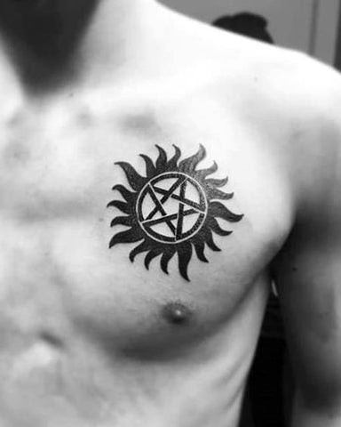 Man with a supernatural chest tattoo featuring mystical symbols and runes