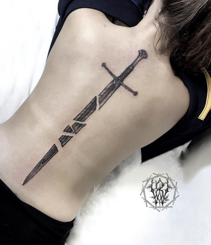 Broken sword tattoo representing a broken heart, the end of a battle, acceptance of defeat, humility, or a reminder to stay grounded.