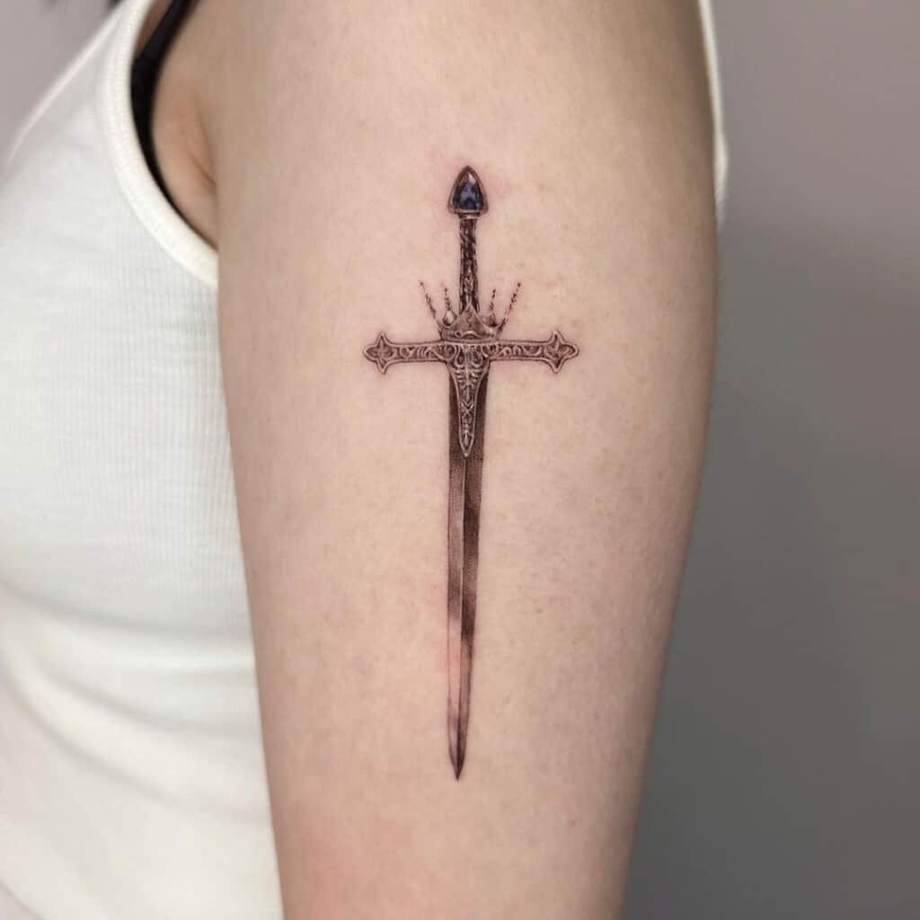 Hand holding sword tattoo design, emphasizing personal agency, control, and the power to wield strength and justice.