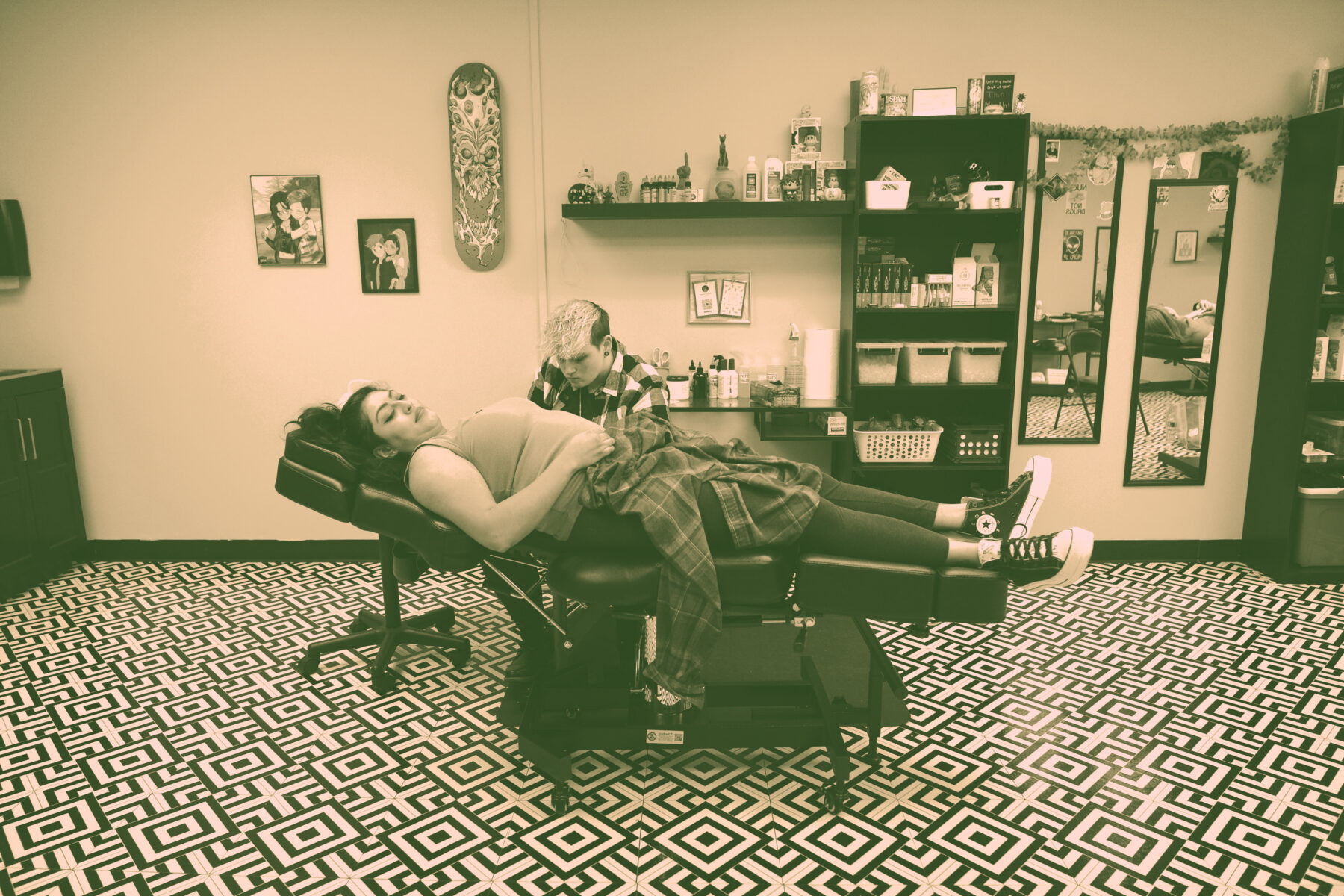 Photo by Lukas Flippo of Sam Jannetty tattooing a client at Broken Crystal Tattoo Studio, showcasing her focused artistry and the clean, organized workspace.