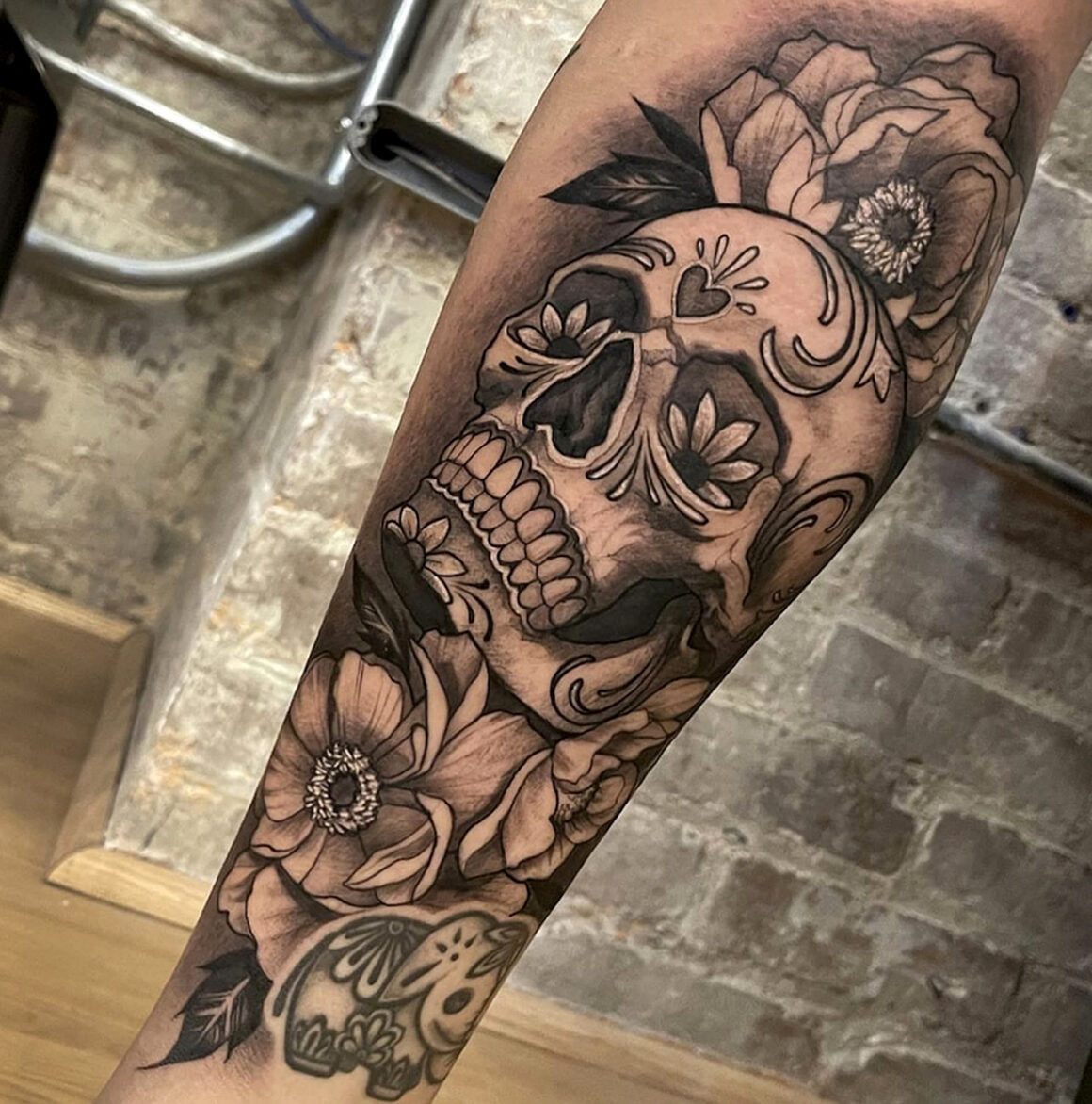 Elaborate black and grey Mexican tattoo showcasing cultural symbolism, by Elvia Guadian