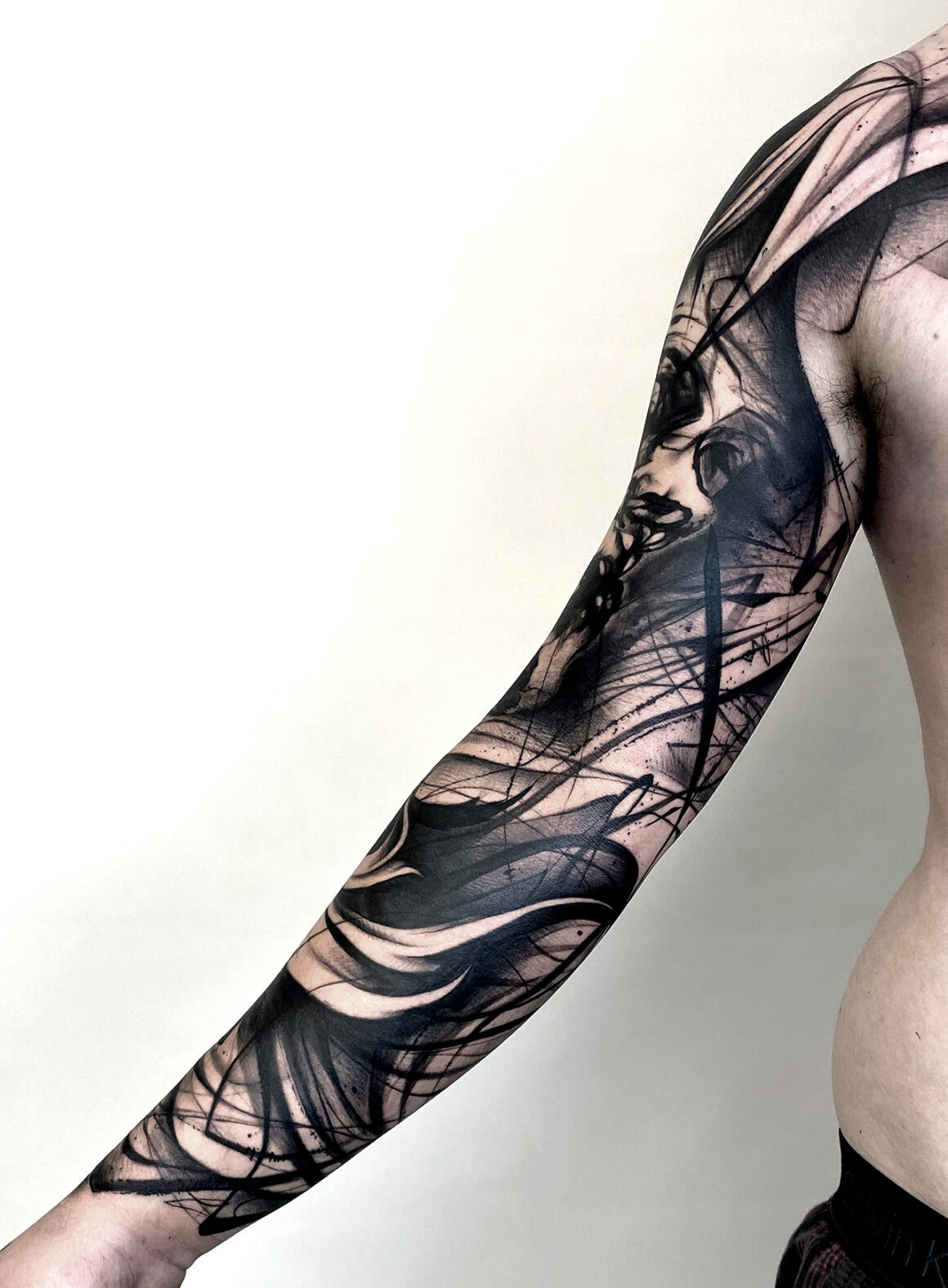 Abstract tattoo on leg with flowing lines, embodying Natalie Nox's organic style