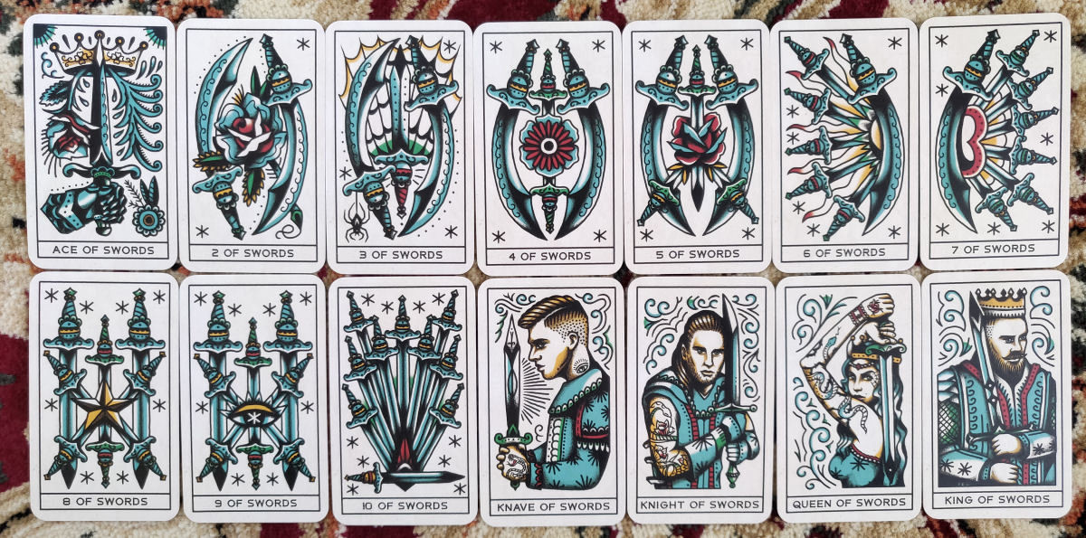 Swords suit cards from the Tattoo Tarot, featuring blue and teal tones and intricate detailing in the pip card designs.