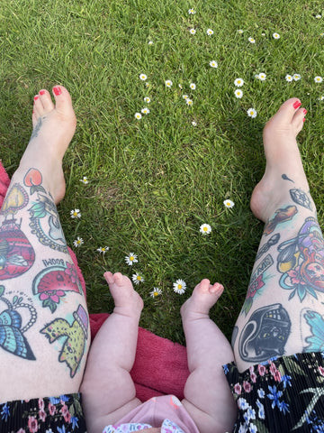 Rosalie and her daughter Avery, sharing a moment while moisturizing Rosalie's tattoos