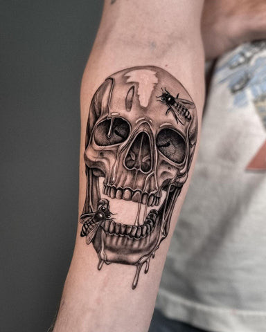 Forearm skull tattoo drawing with intricate shading and gothic elements.