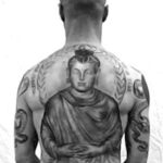 Arm showcasing Buddhist-inspired tattoos, representing personal journey and Zen practice.