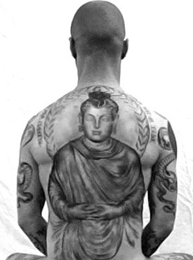 Arm showcasing Buddhist-inspired tattoos, representing personal journey and Zen practice.