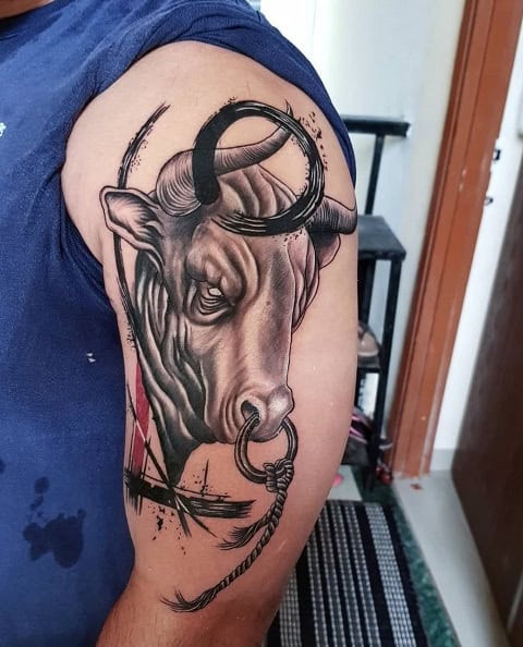 Shoulder tattoo of a bull with floral designs in color ink