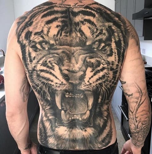 Guardian tiger back tattoo symbolizing protection and luck