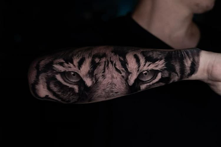 Intense tiger eyes tattoo on forearm