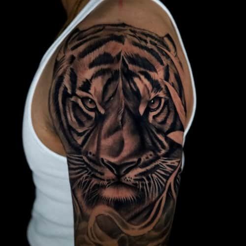 A traditional style tiger tattoo on a man's arm, showcasing bold lines and vibrant colors