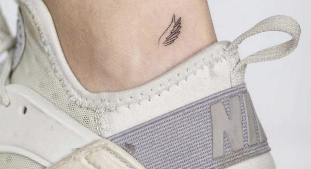 Delicate tiny angel wing tattoo, perfect for minimalist style and discreet placement.