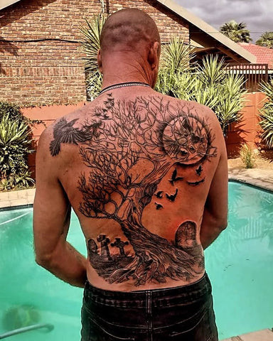 Tree back tattoo art showcasing a detailed tree with roots and branches across the back