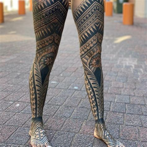 Detailed tribal leg sleeve tattoo on a man's leg