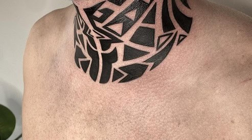 Tribal neck tattoo on a man's neck, featuring a bold tribal design centered on the throat.