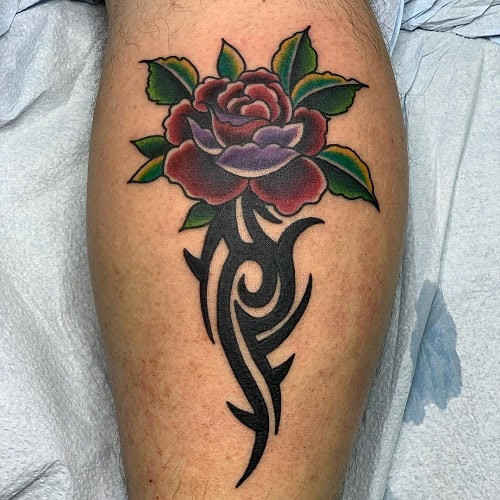 Tribal rose tattoo on a man's hand, showcasing a rose design with sharp tribal lines and thorns.