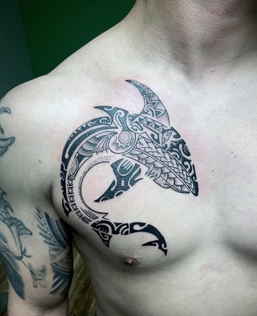 Tribal shark tattoo on a man's leg, depicting a shark with stylized tribal patterns.