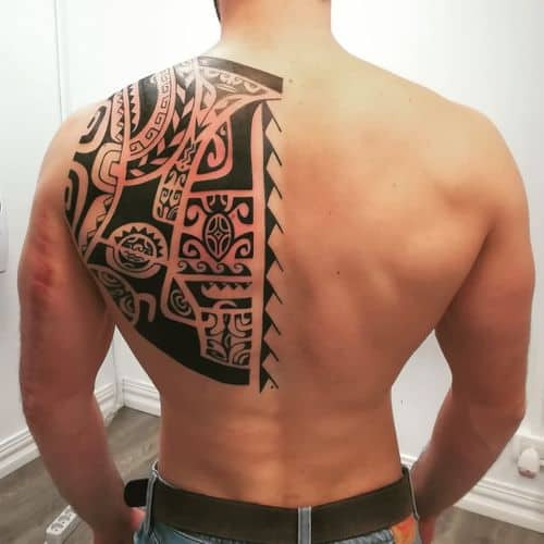 A tribal pattern tattoo with thick black lines on a man's arm, bold and ancestral