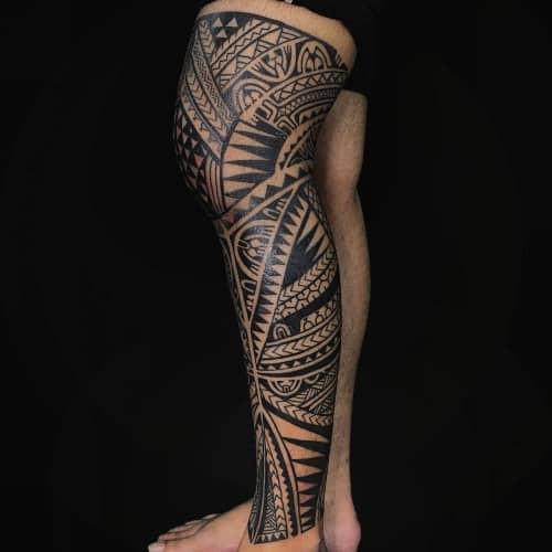 Tribal leg tattoo with intricate patterns, showcasing detailed men tattoo ideas.