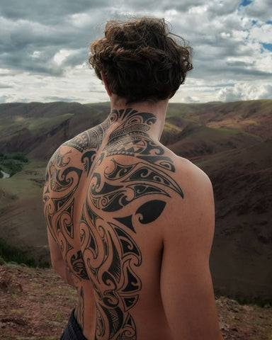 Tribal back tattoo design intricately covering the back, symbolizing heritage and strength