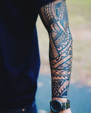 Tribal sleeve tattoo featuring bold black lines and intricate patterns rooted in ancient traditions