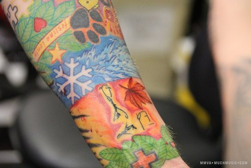 Close-up of leaf tattoos and red shading on Ed Sheeran's lower arm.
